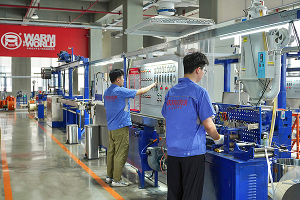 工人在操作電伴熱帶護套擠出設(shè)備。 環(huán)瑞電熱供圖